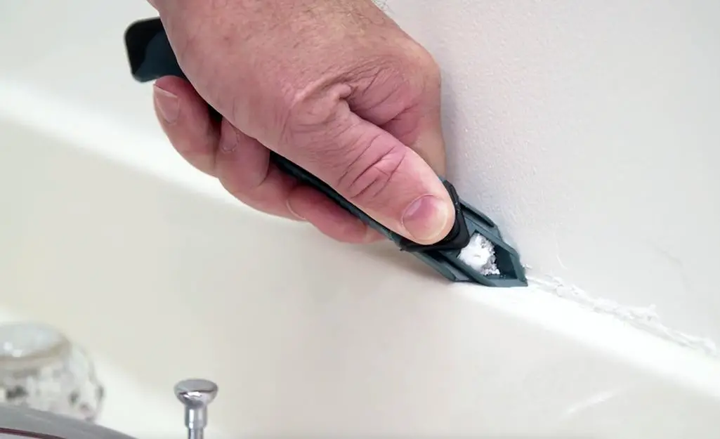 a person Smooth the Caulk| large gap between tub and floor tile